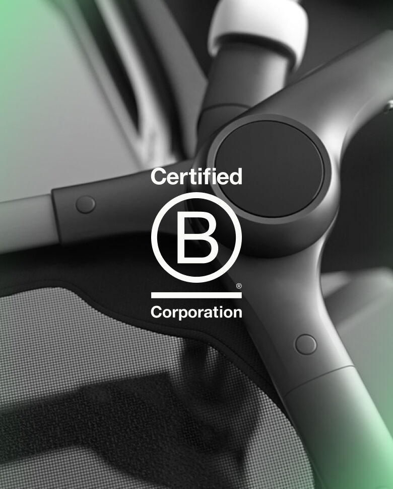 なめらかなブラック色に仕上げたバガブー ストローラーのシャーシ（車体）のクロースアップ。 その画像に『B Corporation認証』のロゴが重なっている。