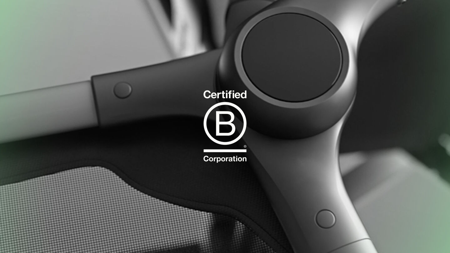 세련된 블랙 컬러로 마감한 부가부 스트롤러 섀시의 클로즈업 이미지입니다. 이미지 위에는 'Certified B Corporation' 로고가 겹쳐 있습니다.