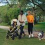 Una famiglia di tre persone e un cane si godono una giornata estiva al parco con il bambino in un passeggino Bugaboo Fox 3. - Thumbnail Slide 3 of 7